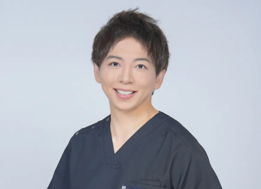 紺色のスクラブを着た院長 平田侑の写真。笑顔でこちらを向いている。