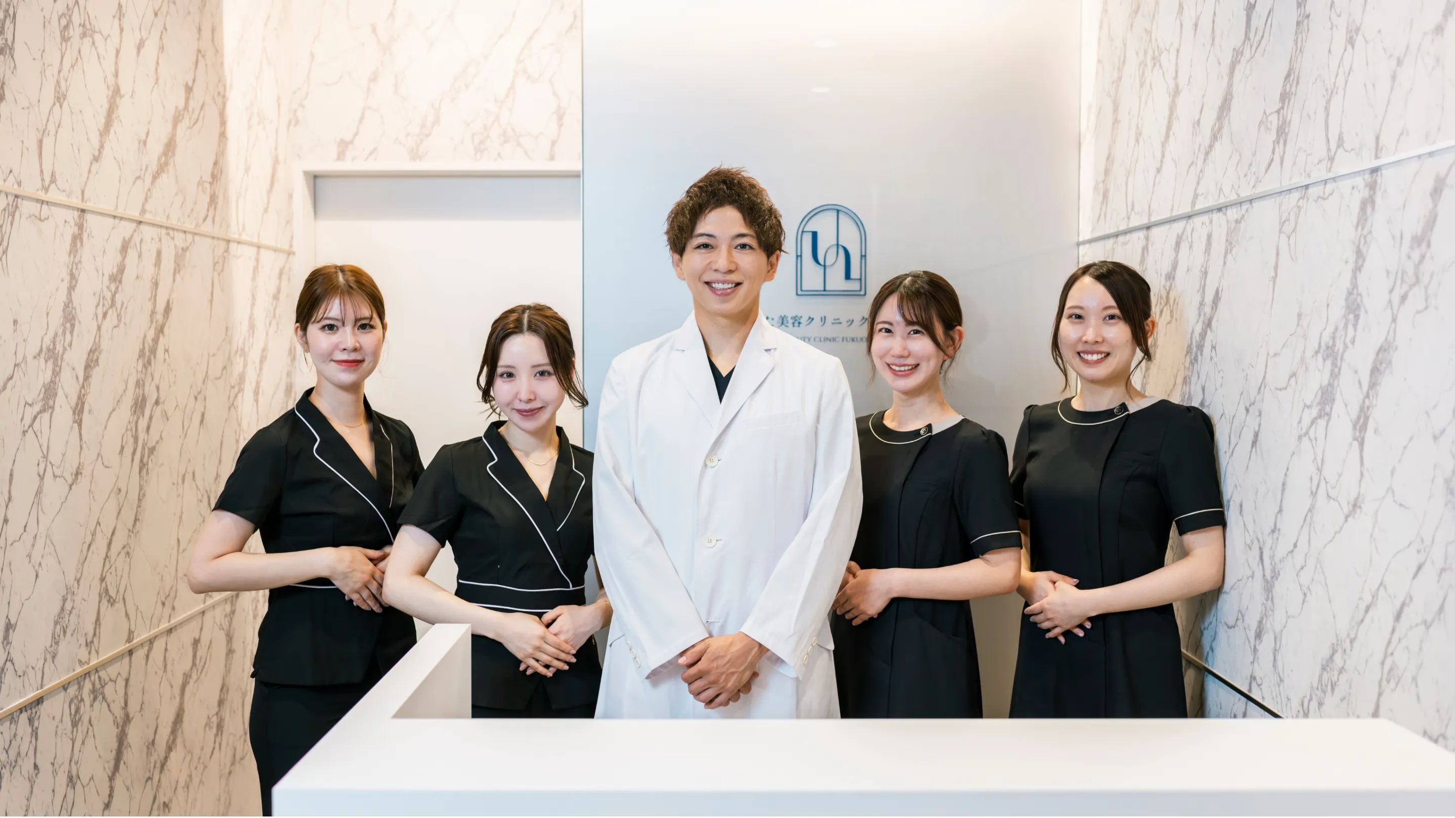 ひらた美容クリニック福岡天神の受付前に並ぶ医師とスタッフ